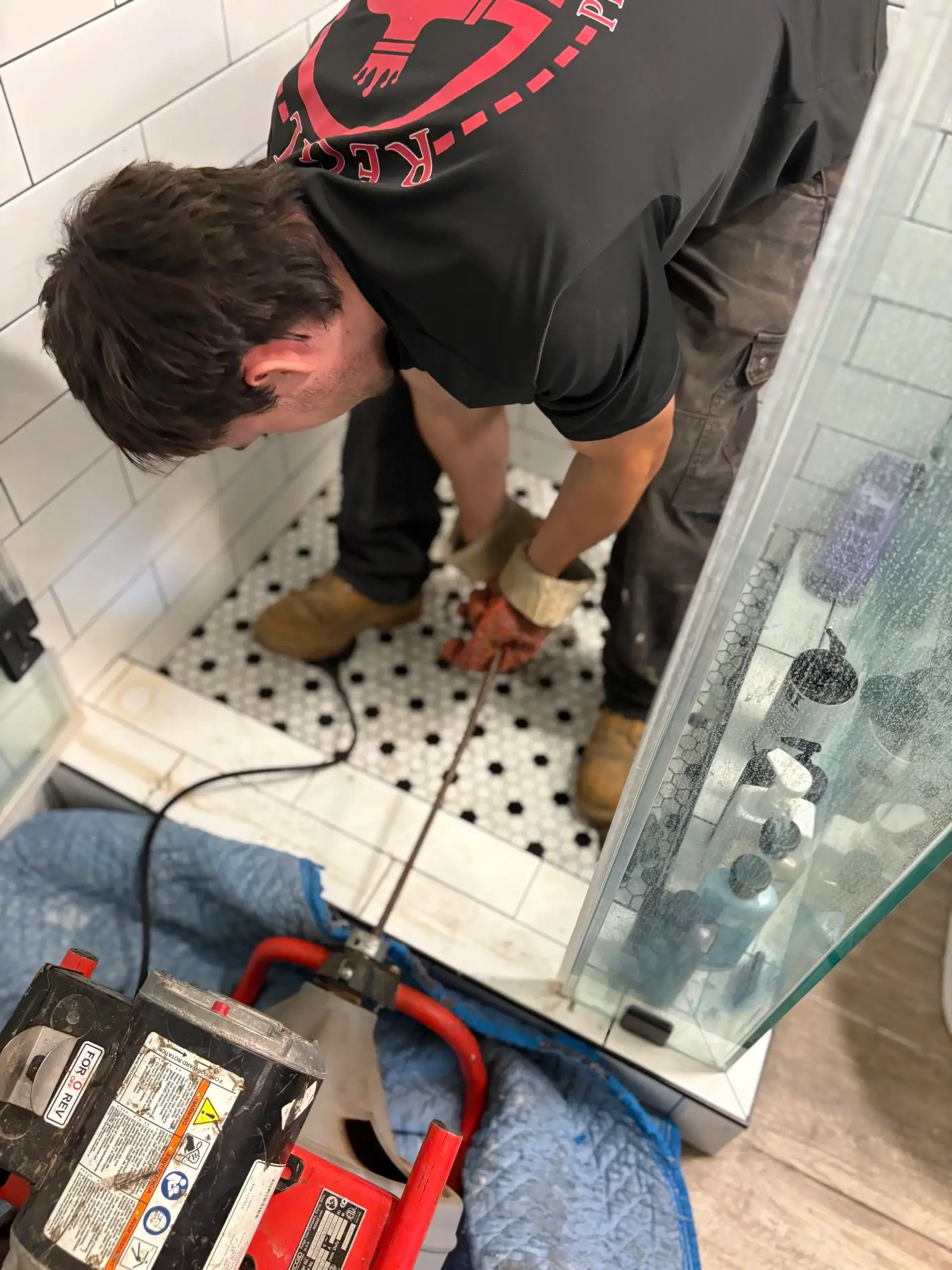 Regal Plumbing & Rooter technician using drain cleaning machine in a shower in Upland, CA