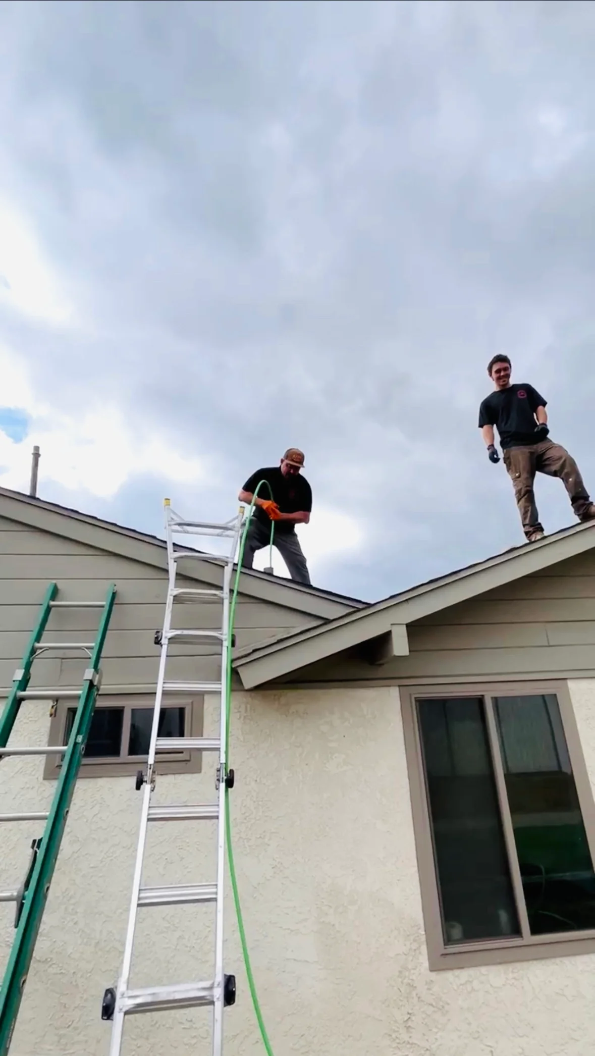 Two Regal Plumbing & Rooter technicians on a roof using hydrojetting equipment for drain maintenance in Rancho Cucamonga, CA