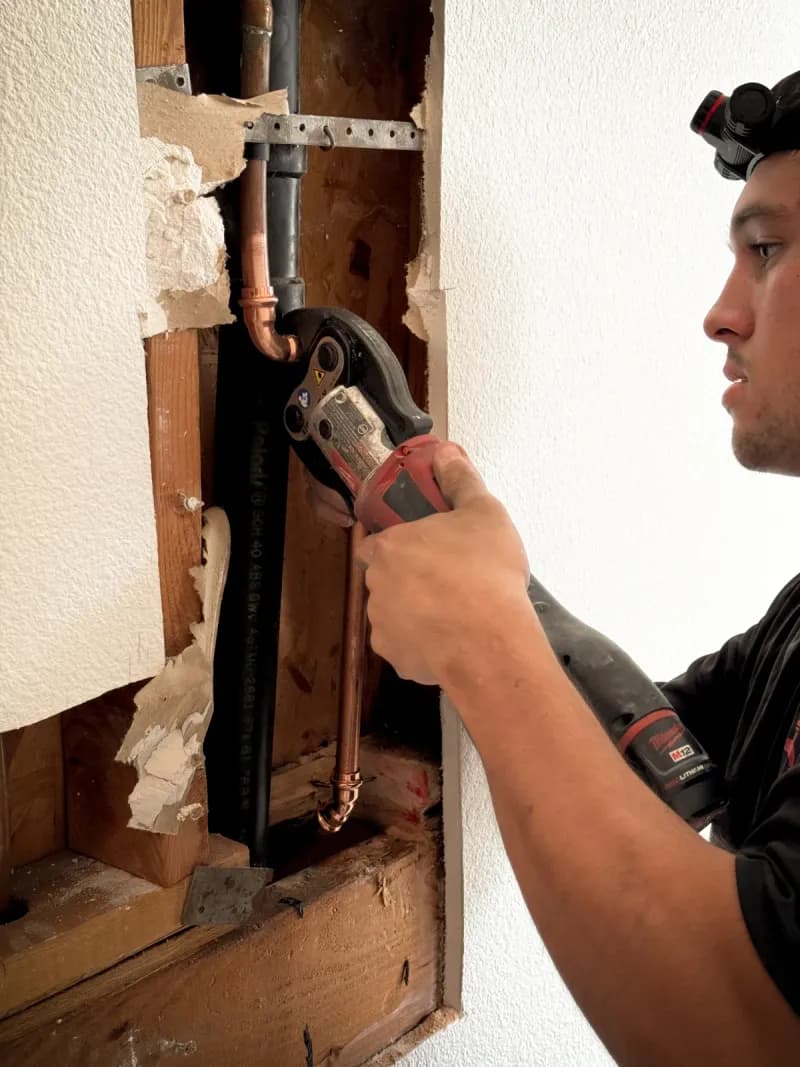 Regal Plumbing & Rooter technician cutting copper piping for pipe repair service in Pomona, CA
